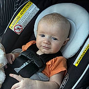 Bradlee joined the competition — help win amazing prizes! baby, infant, car_seat, child, straps, orange_shirt, warning_label, seatbelt, cute, face, head, sitting, safety, child_seat, car, transport, young_child, skin, hand, expression