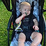 Bradlee joined the competition — help win amazing prizes! baby, stroller, outdoor, grass, pacifier, child, infant, diaper, black_onesie, toy, seat_belt, baby_toy, curious, legs, head, face, person, summer, sunlight, comfort