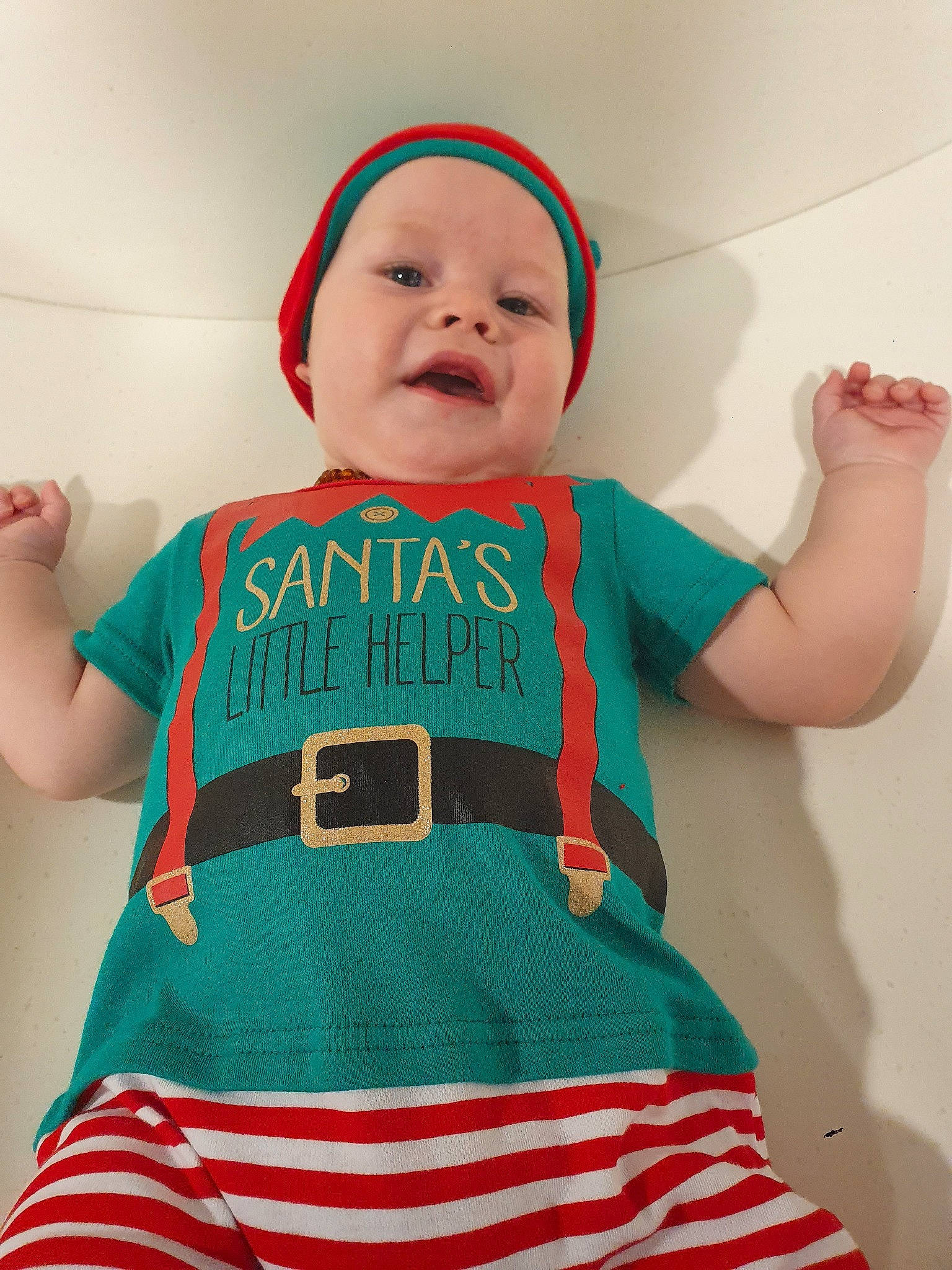 Xavier is registered to the contest to win money with this photo: arm, baby, baby_toddler_clothing, blue, child, costume, fashion_accessory, finger, green, hand, person, red, sleeve, t_shirt, teal, textile, toddler, turquoise