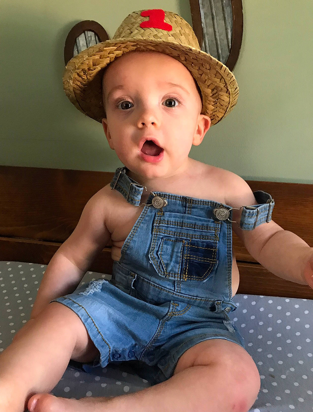 Judson is registered to the contest to win money with this photo: baby, child, child_model, clothing, cowboy_hat, fashion_accessory, hat, headgear, leg, person, plaid, sitting, skin, sun_hat, surprise, thigh, toddler