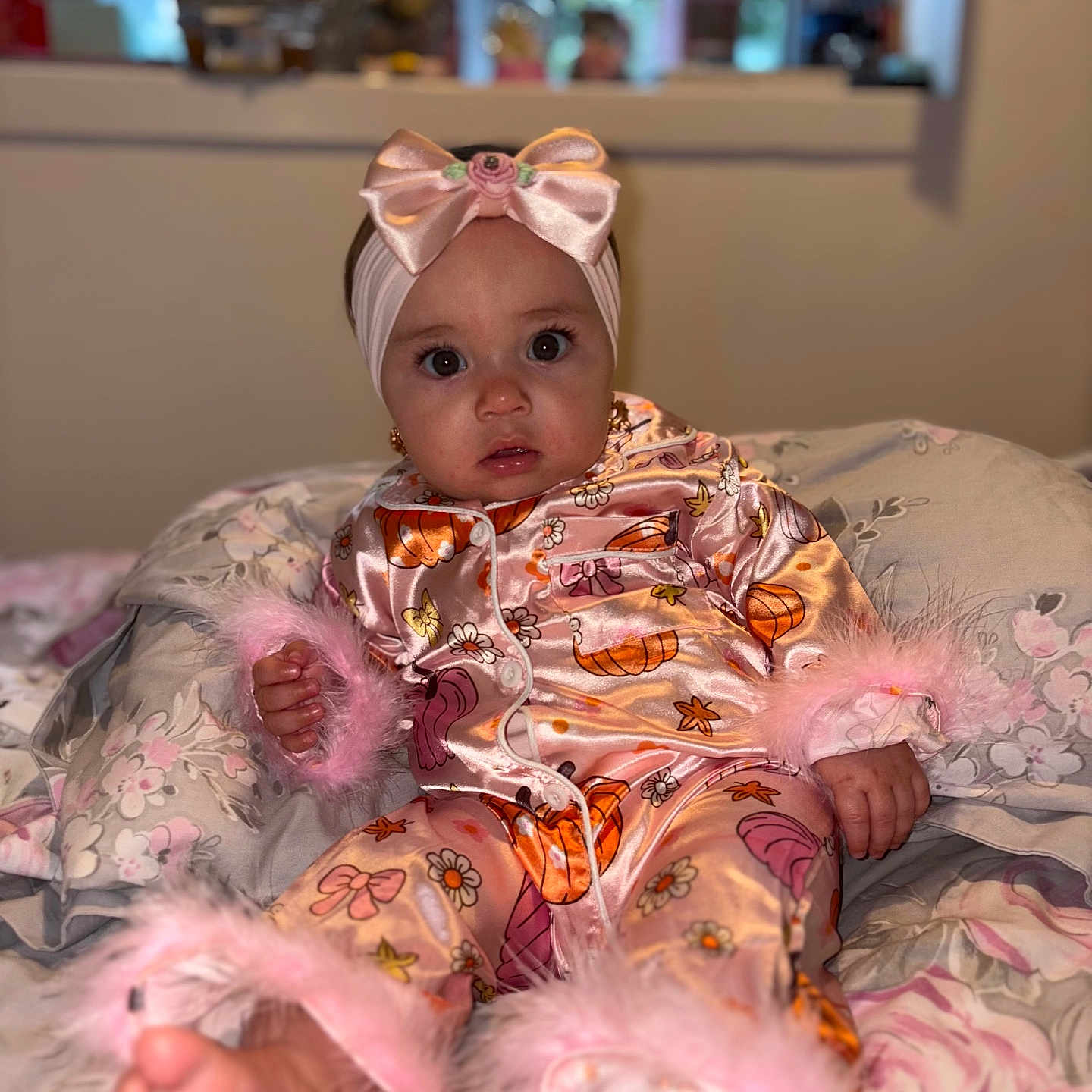 Marykate joined the competition — help win amazing prizes! baby, bedroom, blanket, child, clothing, cozy, curious_expression, cute, feet, floral_pattern, hand, headband, indoors, infant, pajamas, pink_bow, portrait, sitting, soft_toys, young_child