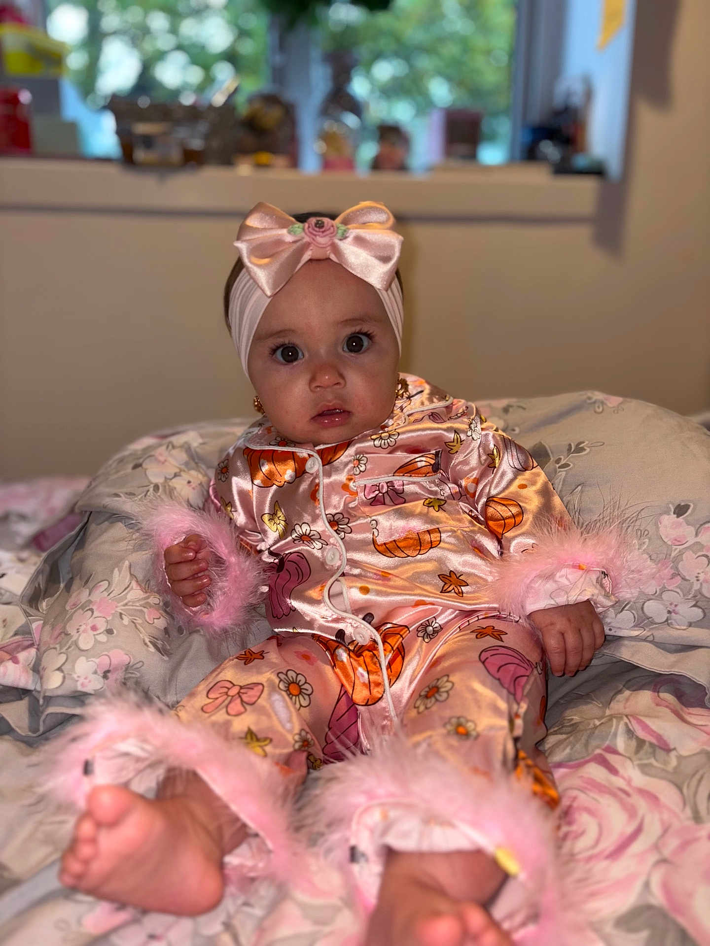 Marykate joined the competition — help win amazing prizes! baby, child, pajamas, pink_bow, headband, sitting, blanket, floral_pattern, indoors, cute, infant, feet, hand, curious_expression, soft_toys, bedroom, cozy, clothing, portrait, young_child