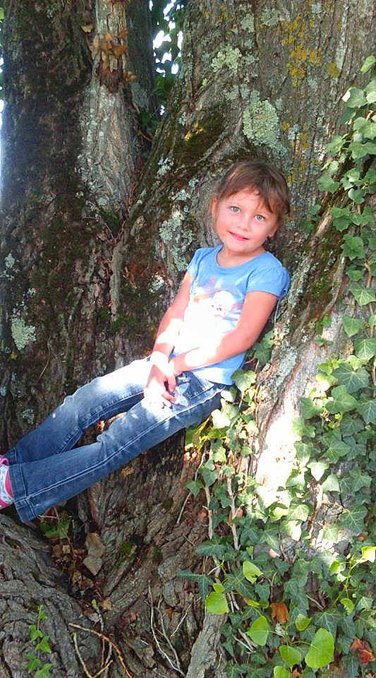 Léna a rejoint le concours — aidez-le/la à gagner de superbes lots ! biome, branch, electric_blue, forest, fun, grass, jeans, joy, jungle, old_growth_forest, people_in_nature, person, plant, sitting, t_shirt, terrestrial_plant, toddler, tree, trunk, wood