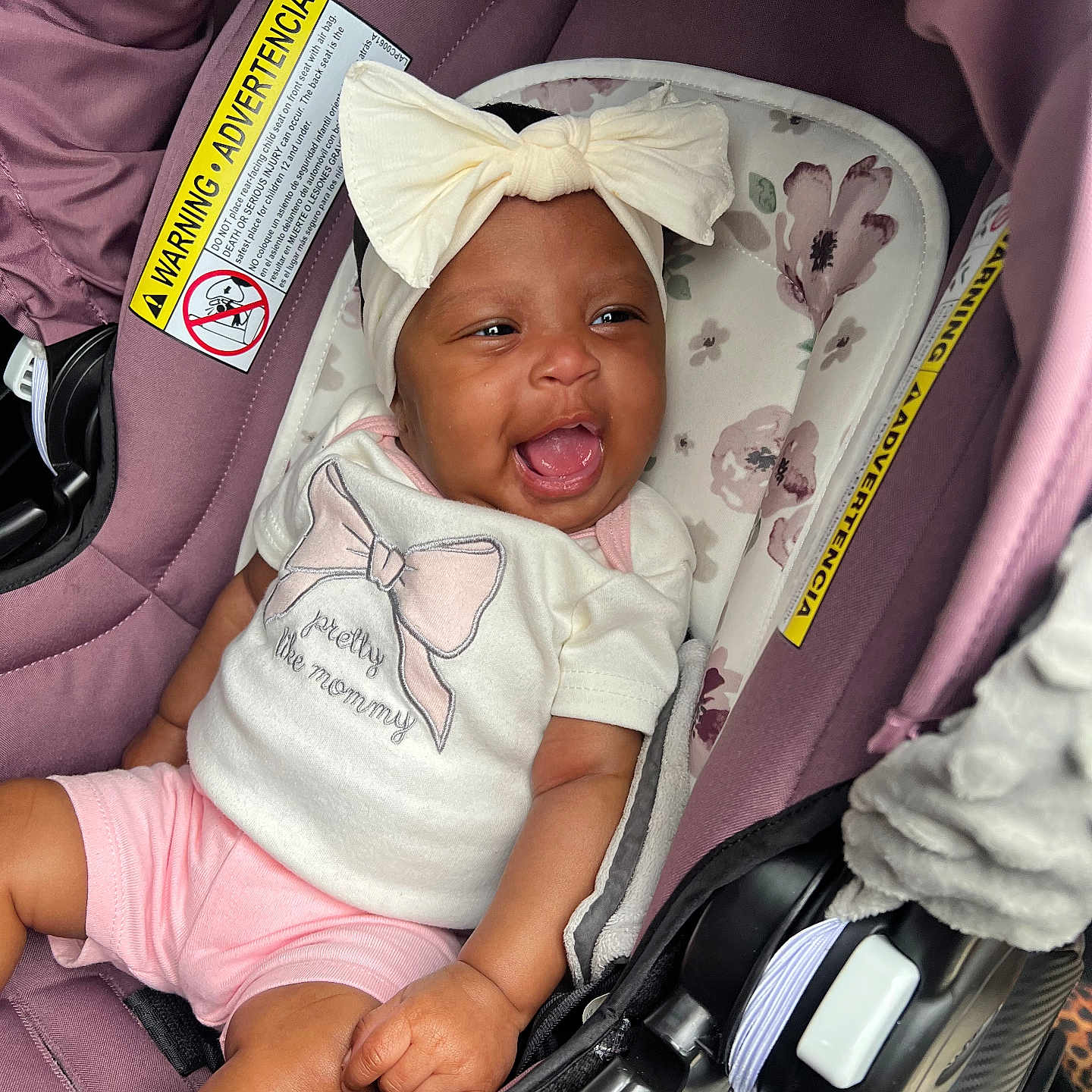 Chamyah joined the competition — help win amazing prizes! baby, infant, child, smiling, happy, portrait, car_seat, bow, headband, white_shirt, pink_shorts, clothing, floral_pattern, vehicle, automobile, indoor, seated, gummy_smile, safety_label, photography