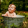baby, child, metal_tub, outdoor, nature, greenery, grass, leaves, wet_hair, curious, playful, skin, infant, summer, daylight, portrait, sitting, cute, young, bare_chested