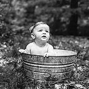 Sawyer is registered to the contest to win money with this photo: baby, child, metal_tub, outdoor, grass, nature, black_and_white, portrait, curious, wide_eyes, sitting, forest, bare_shoulders, infant, expression, young_child, monochrome, photography, rustic, background_blur