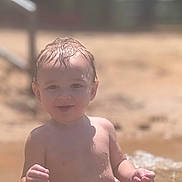Nathon joined the competition — help win amazing prizes! toddler, child, water, beach, sand, wet_hair, red_swim_trunks, sunlight, smiling, outdoor, summer, playing, happy, sitting, bare_chest, young_child, vacation, fun, nature, portrait