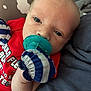 baby, blue_stripes, closeup, clothing, comfort, cute, eyes, face, head, indoor, infant, mittens, newborn, pacifier, person, portrait, red_shirt, resting, skin, soft