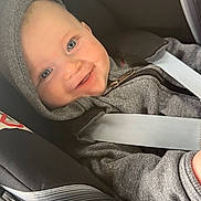 Maël a rejoint le concours — aidez-le/la à gagner de superbes lots ! baby, blue_eyes, buckle, car_seat, child, close_up, cuteness, face, grey_clothing, hand, happy, hoodie, infant, interior, portrait, safety, seat, seatbelt, smile, vehicle