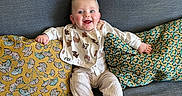 Maël participe au concours pour gagner de l'argent avec cette photo : baby, bib, child, corduroy_pants, couch, cozy, fabric_texture, happy, home_interior, infant, patterned_pillow, pillow, playful, portrait, sitting, smiling, socks, striped_socks, sunglasses, wall