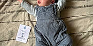 Maël a rejoint le concours — aidez-le/la à gagner de superbes lots ! baby, infant, bed, blanket, clothing, overalls, socks, face, person, lying_down, newborn, one_month, card, pattern, striped_socks, cute, small, indoors, resting, celebration