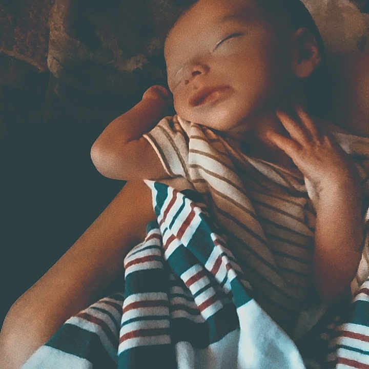 Gage Ridings joined the competition — help win amazing prizes! baby, sleeping, blanket, striped_clothing, arm, peaceful, infant, person, rest, comfort, portrait, cozy, hands, soft_light, indoor, closeup, toddler, young_child, warmth, care