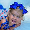 Serinaty joined the competition — help win amazing prizes! child, toddler, blue_bow, blue_eyes, curly_hair, playful, tongue_out, smiling, closeup, portrait, blue_dress, earrings, cute, happy, skin, face, person, lying_down, light_background, expression