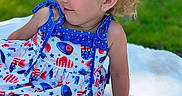 Serinaty is registered to the contest to win money with this photo: blanket, blue_bow, child, curly_hair, cute, dress, earrings, fashion, grass, happy, outdoor, playful, popsicle_pattern, portrait, sitting, smile, summer, sunlight, toddler, young_child