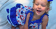 Serinaty is registered to the contest to win money with this photo: toddler, child, girl, blue_bows, curly_hair, dress, crawling, blanket, outdoor, grass, sunlight, happy, smiling, cute, summer, playful, person, portrait, baby, nature