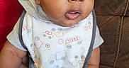 Onyx is registered to the contest to win money with this photo: baby, infant, child, bib, clothing, socks, couch, furniture, face, eyes, hands, sitting, cute, skin, hoodie, expression, indoor, portrait, person, young