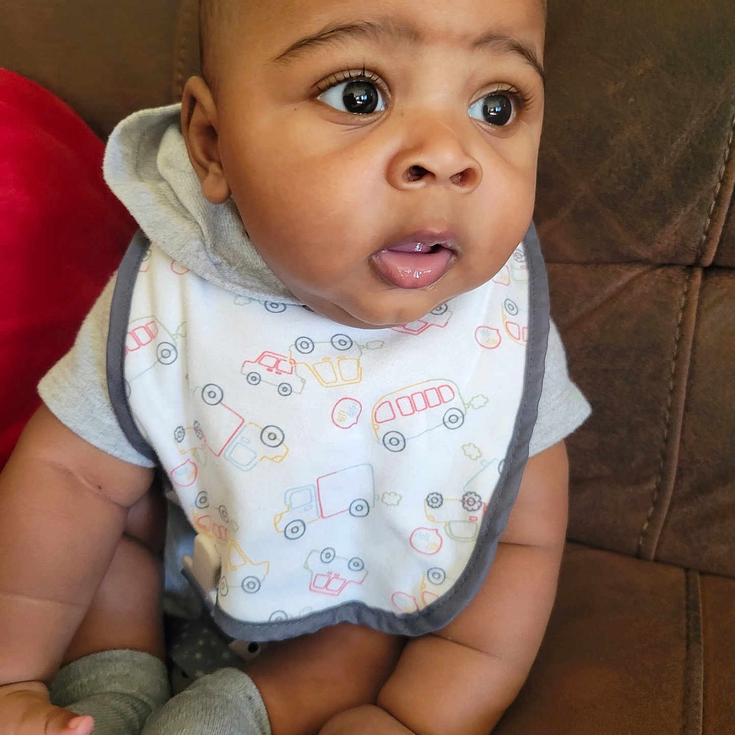 Onyx is registered to the contest to win money with this photo: baby, infant, child, bib, clothing, socks, couch, furniture, face, eyes, hands, sitting, cute, skin, hoodie, expression, indoor, portrait, person, young