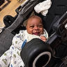 baby, baby_accessory, baby_cart, baby_garment, child, clothing, cute, fabric, face, happy, indoor, infant, joy, onesie, person, seat, smiling, sock, stroller, toy
