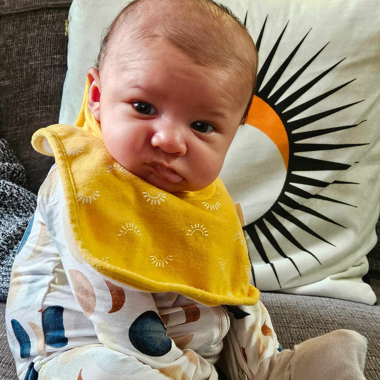 Anthony is registered to the contest to win money with this photo: applique, baby, bib, blanket, chair, clothing, couch, cushion, face, furniture, head, homedecor, newborn, pants, person, photography, pillow, portrait, quilt, sitting