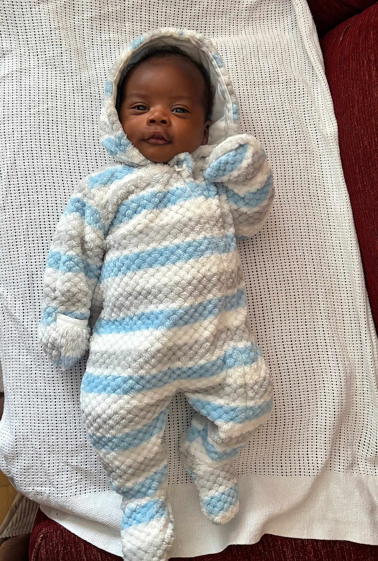 Chidubem joined the competition — help win amazing prizes! baby, infant, onesie, blue, white, striped, hooded, blanket, smiling, face, lying_down, cozy, warm, cute, child, indoors, soft, apparel, person, newborn
