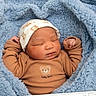 newborn, baby, sleeping, infant, portrait, face, blanket, blue_blanket, cozy, clothing, hat, beanie, brown_outfit, bear_design, baby_bear, indoors, close_up, peaceful, cute, photograph