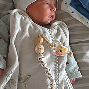 Kealyan participe au concours pour gagner de l'argent avec cette photo : newborn, baby, infant, pacifier, beads, blanket, hat, swaddle, sleeping, face, hand, toy, bed, striped_bedding, cozy, portrait, closeup, onesie, pacifier_clip, nursery