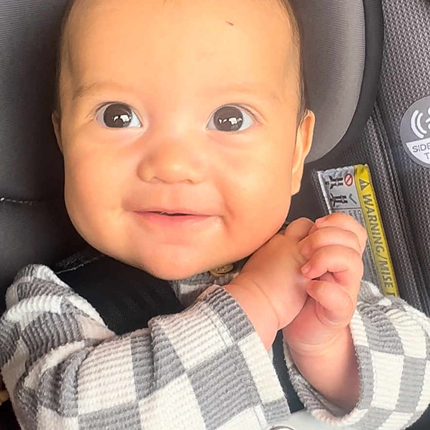 Asher is registered to the contest to win money with this photo: accessories, baby, belt, bodypart, car, cushion, face, finger, hand, happy, head, homedecor, newborn, person, photography, portrait, smile, text, transportation, vehicle