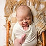 newborn, baby, smiling, tongue_out, wrapped, blanket, wicker_basket, cozy, infant, cute, sleeping, soft, skin, hands, feet, portrait, closeup, peaceful, child, indoors
