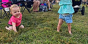 Cali And Oakleigh is registered to the contest to win money with this photo: toddler, child, grass, outdoor, people, smile, crawling, standing, chairs, adult, casual_clothing, sunlight, event, family, happy, nature, daytime, stroller, lawn, relaxation