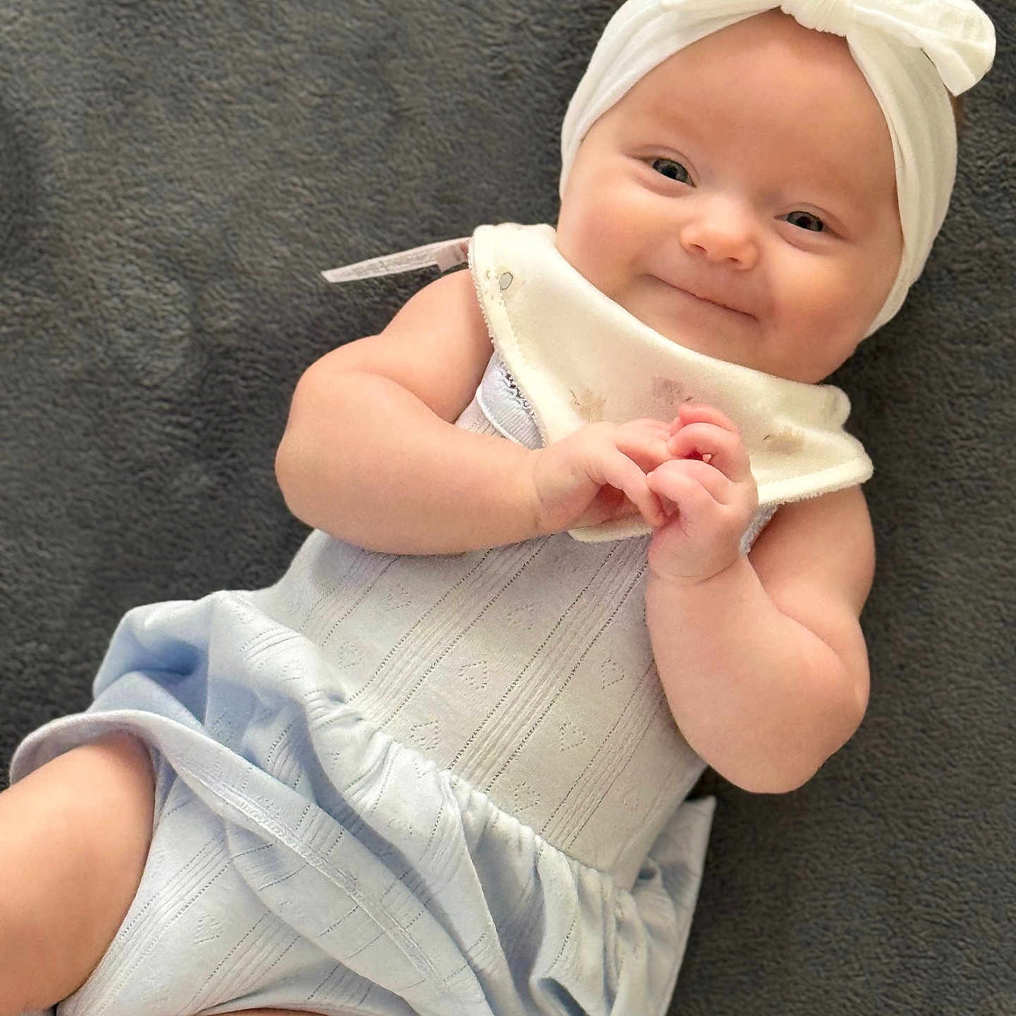 Kj joined the competition — help win amazing prizes! baby, infant, smile, headband, bow, dress, clothing, blanket, lying_down, cute, hands, happy, soft_texture, portrait, child, skin, one_person, indoors, toddler, baby_girl