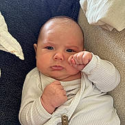 Noa a rejoint le concours — aidez-le/la à gagner de superbes lots ! baby, infant, newborn, face, eyes, fist, onesie, pacifier_clip, couch, pillow, blanket, indoors, portrait, chubby_cheeks, skin, expression, hand, cozy, sleeve, lying_down