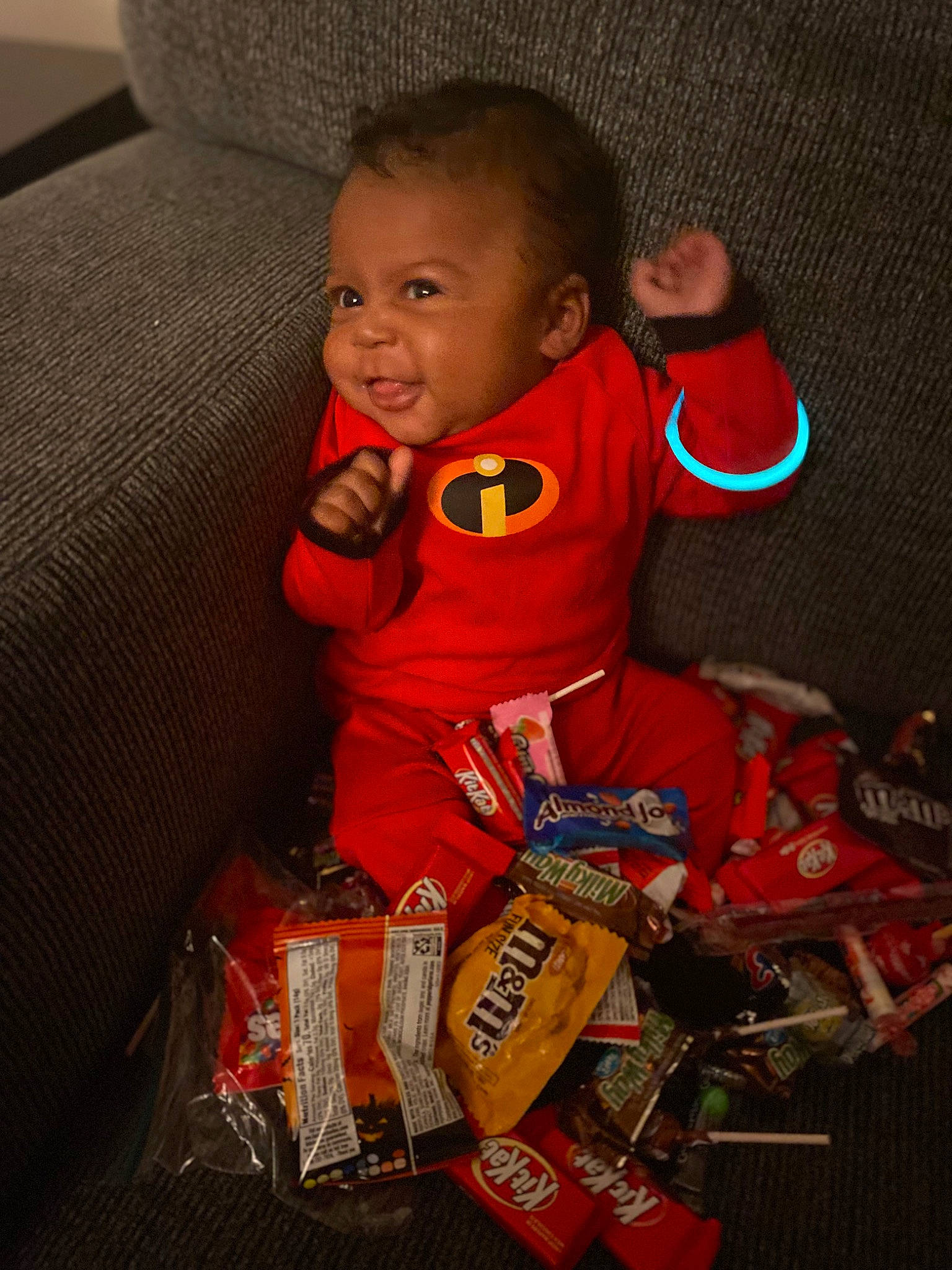 Zayvion is registered to the contest to win money with this photo: baby, baby_products, baby_toddler_clothing, child, comfort, couch, eye, fun, happy, head, human_body, orange, person, product, sitting, sleeve, smile, t_shirt, toddler, toy