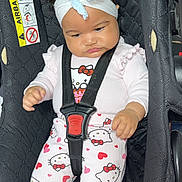 Luciana-Nicole is registered to the contest to win money with this photo: baby, child, car_seat, headband, bow, hello_kitty, pajamas, hearts, black, straps, cute, infant, seated, clothing, indoors, portrait, expression, safety, car, seat
