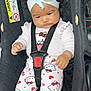 baby, child, car_seat, headband, bow, hello_kitty, pajamas, hearts, black, straps, cute, infant, seated, clothing, indoors, portrait, expression, safety, car, seat