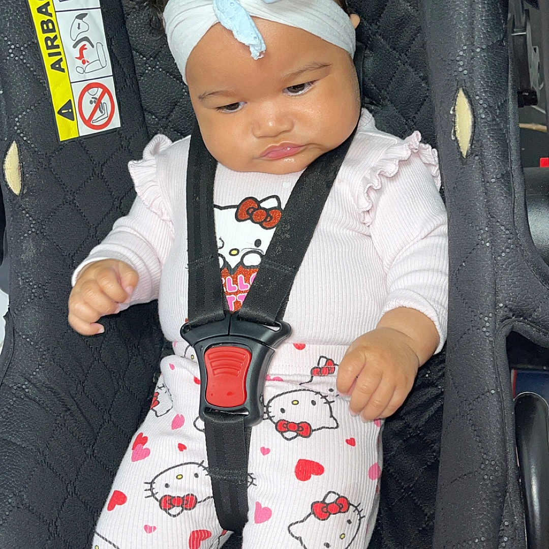 Luciana-Nicole is registered to the contest to win money with this photo: baby, black, bow, car, car_seat, child, clothing, cute, expression, headband, hearts, hello_kitty, indoors, infant, pajamas, portrait, safety, seat, seated, straps
