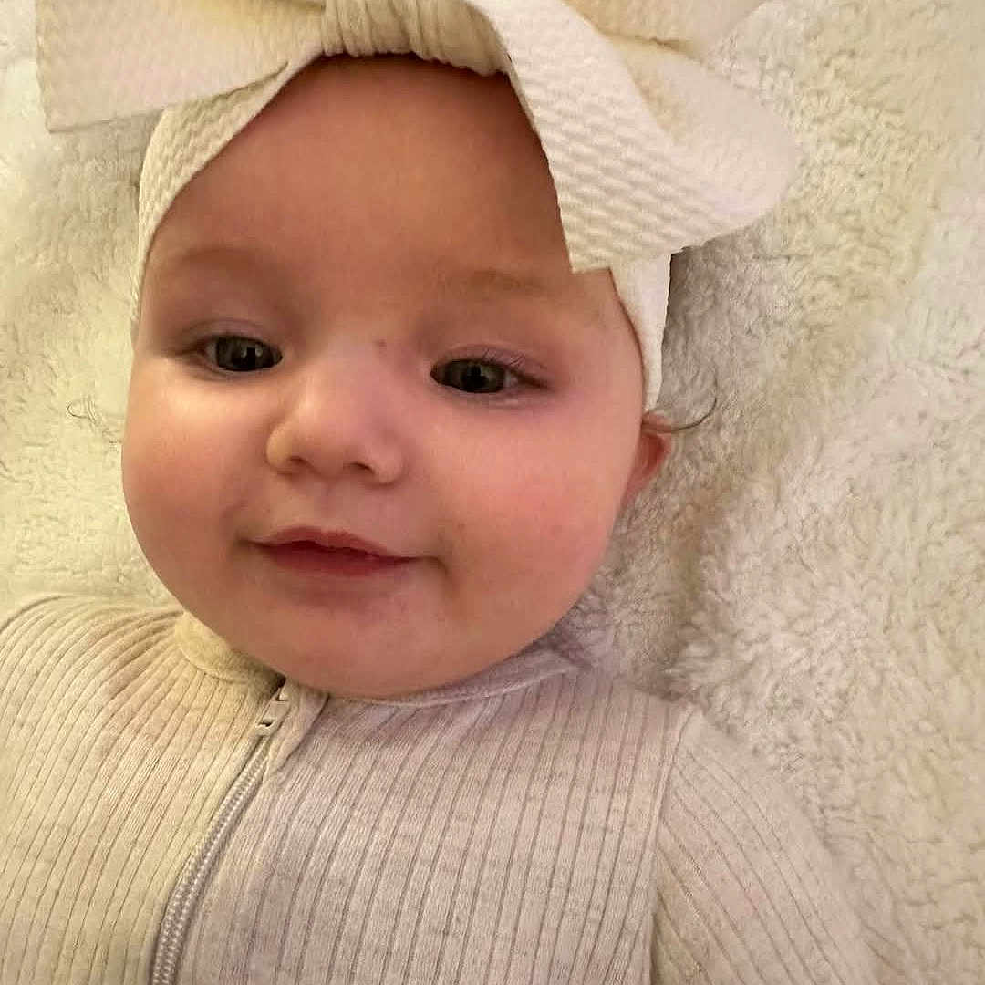 Stormi joined the competition — help win amazing prizes! baby, babylaughing, bodypart, bonnet, cap, clothing, face, happy, hat, head, newborn, person, photography, portrait, shoulder, sleeve, smile