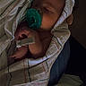 baby, infant, sleeping, pacifier, blanket, swaddled, portrait, face, eyes_closed, cozy, indoors, bed, bedding, relaxed, peaceful, newborn, dark_lighting, closeup, child, resting