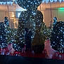 child, night, lights, decoration, holiday, silhouette, outdoor, dark, festive, display, person, illumination, artificial_light, shadow, public_space, structure, blur, celebration, twinkle, background