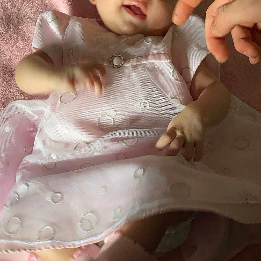 Ayla is registered to the contest to win money with this photo: baby, bed, blanket, bodypart, clothing, dress, face, finger, furniture, hand, happy, head, newborn, person, photography, portrait, sitting, sleeping, sleeve, smile
