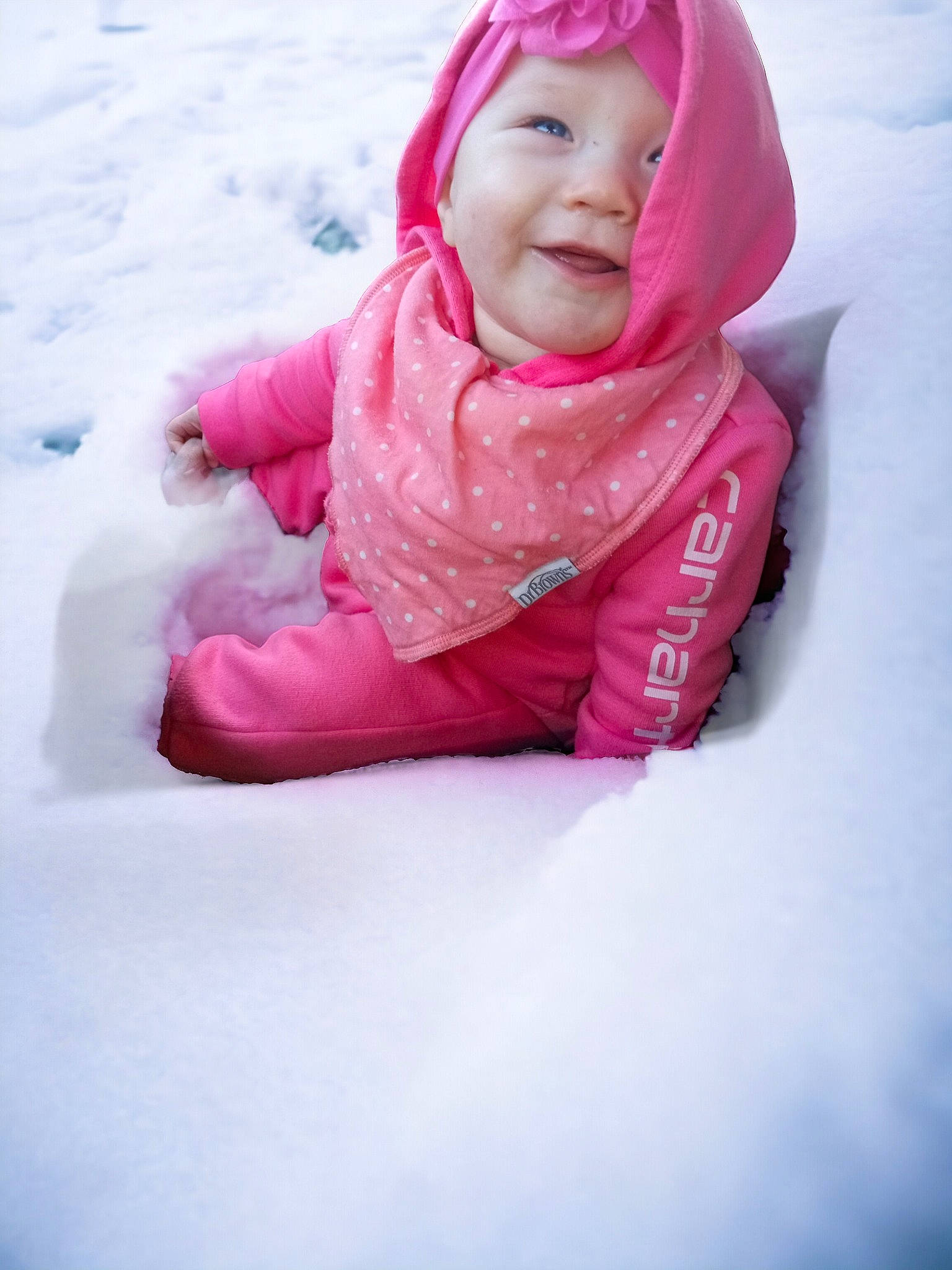 Tiana is registered to the contest to win money with this photo: baby, baby_toddler_clothing, child, fashion_accessory, freezing, fun, happy, headgear, headwear, hood, jacket, magenta, person, pink, portrait_photography, recreation, sitting, sleeve, smile, snow