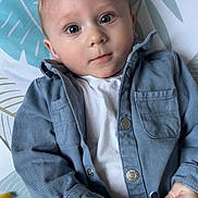 élio participe au concours pour gagner de l'argent avec cette photo : baby, child, infant, blue_jacket, white_shirt, stuffed_toy, hand, face, eyes, blanket, pattern, leaf_pattern, curious, lying_down, portrait, indoor, cute, soft_light, casual_clothing, young