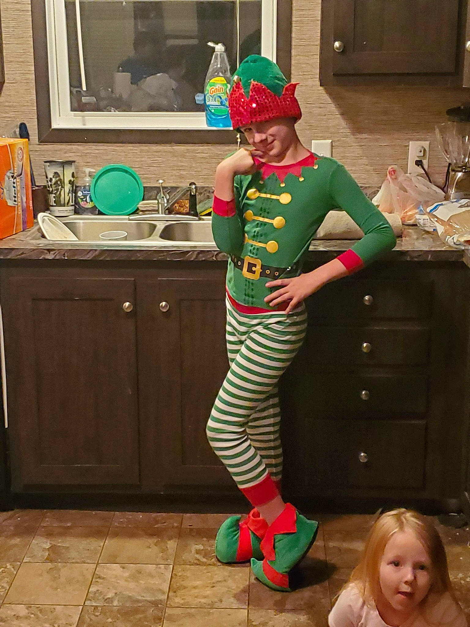 Seth joined the competition — help win amazing prizes! boot, cabinetry, chest_of_drawers, clown, costume, drawer, fashion_design, fictional_character, flooring, fun, green, hat, headwear, kitchen, leg, person, picture_frame, pink, room, standing
