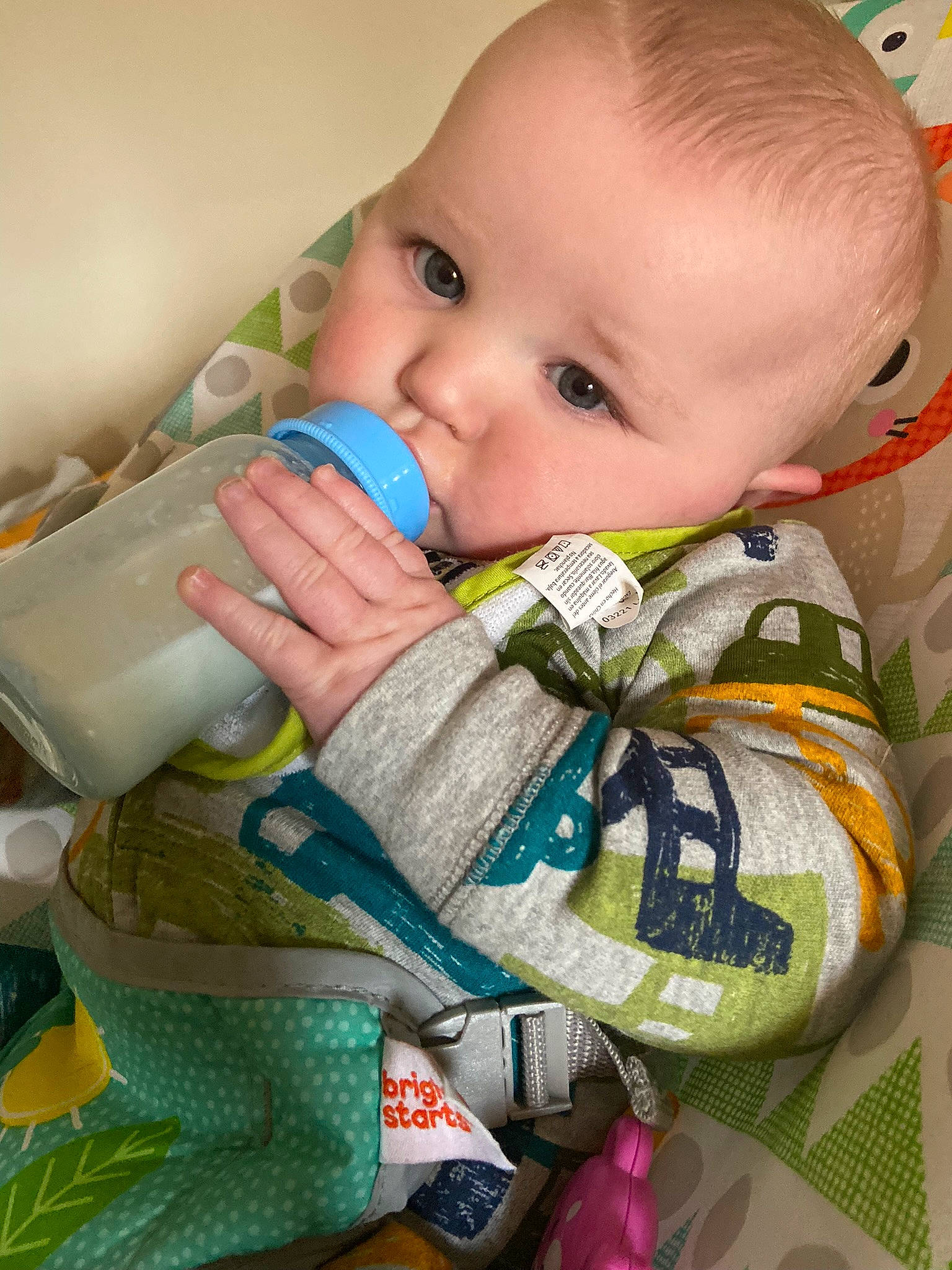 Travis is registered to the contest to win money with this photo: baby, baby_products, baby_toddler_clothing, cheek, child, drinkware, eye, face, finger, happy, head, iris, nose, pattern, person, plastic_bottle, product, sitting, skin, textile
