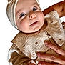 Maddison is registered to the contest to win money with this photo: baby, child, face, headband, blue_eyes, long_eyelashes, hand, ring, clothing, cream_color, heart_pattern, textured_fabric, portrait, cute, smiling, closeup, infant, soft_lighting, human, newborn