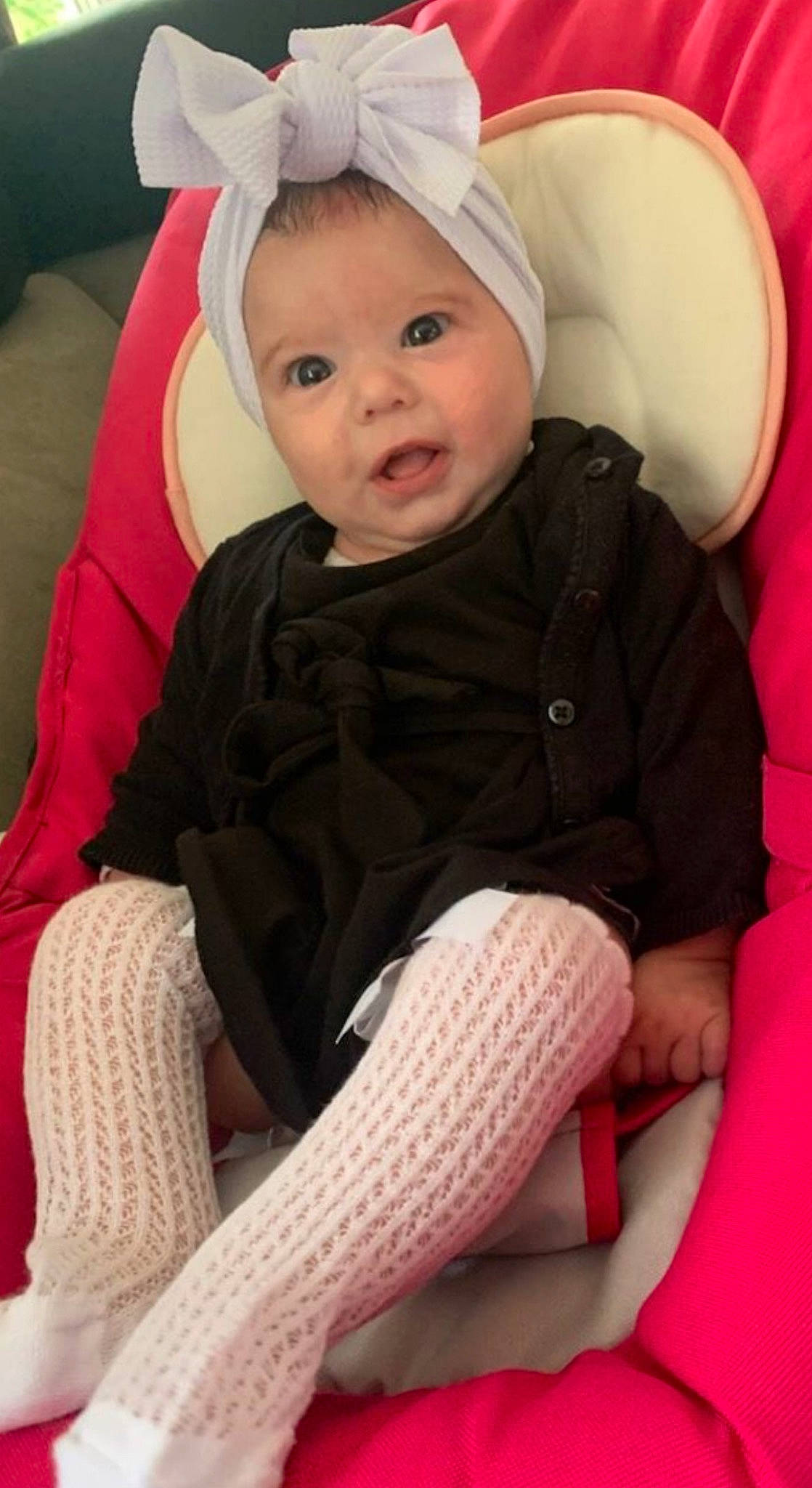 Miyah a rejoint le concours — aidez-le/la à gagner de superbes lots ! baby, baby_toddler_clothing, black, cap, cheek, comfort, finger, head, headwear, human_body, human_leg, knee, lap, person, pink, sitting, skin, sleeve, smile, sock