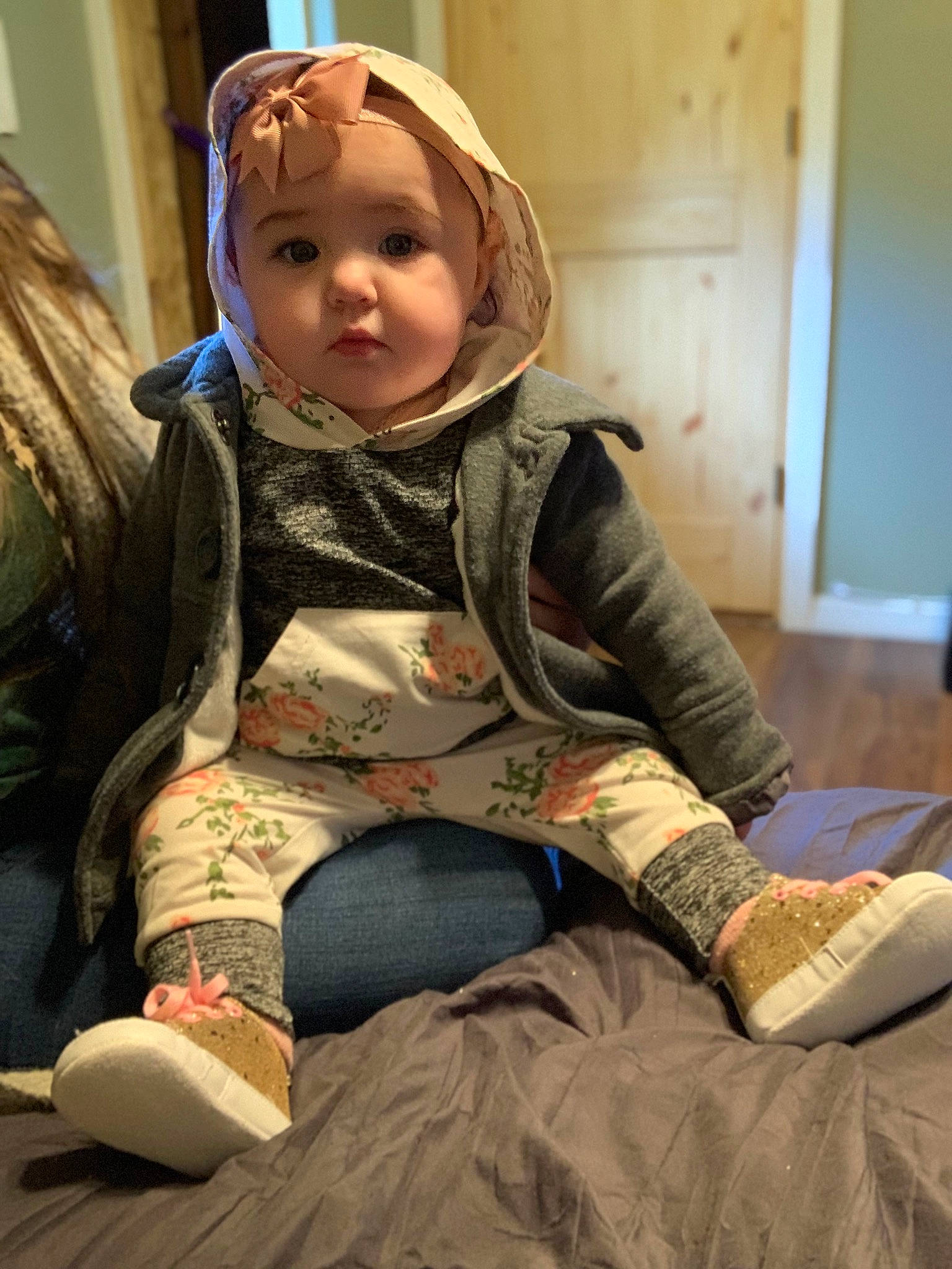 Karina is registered to the contest to win money with this photo: baby, baby_products, child, comfort, flooring, fun, fur, headwear, human_leg, jacket, knee, lap, pattern, person, personal_protective_equipment, room, sitting, textile, thigh, toddler