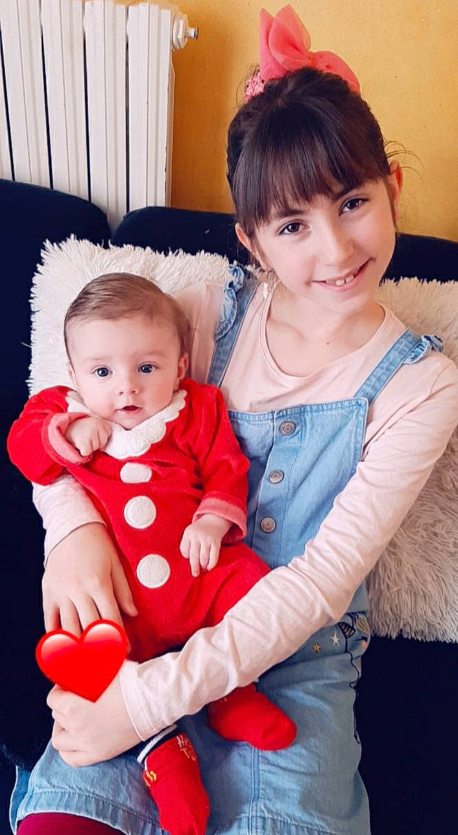 Mylann a rejoint le concours — aidez-le/la à gagner de superbes lots ! arm, baby_toddler_clothing, cheek, dress, eye, face, facial_expression, happy, human, human_body, interaction, joy, leg, mammal, organ, person, pink, skin, sleeve, smile