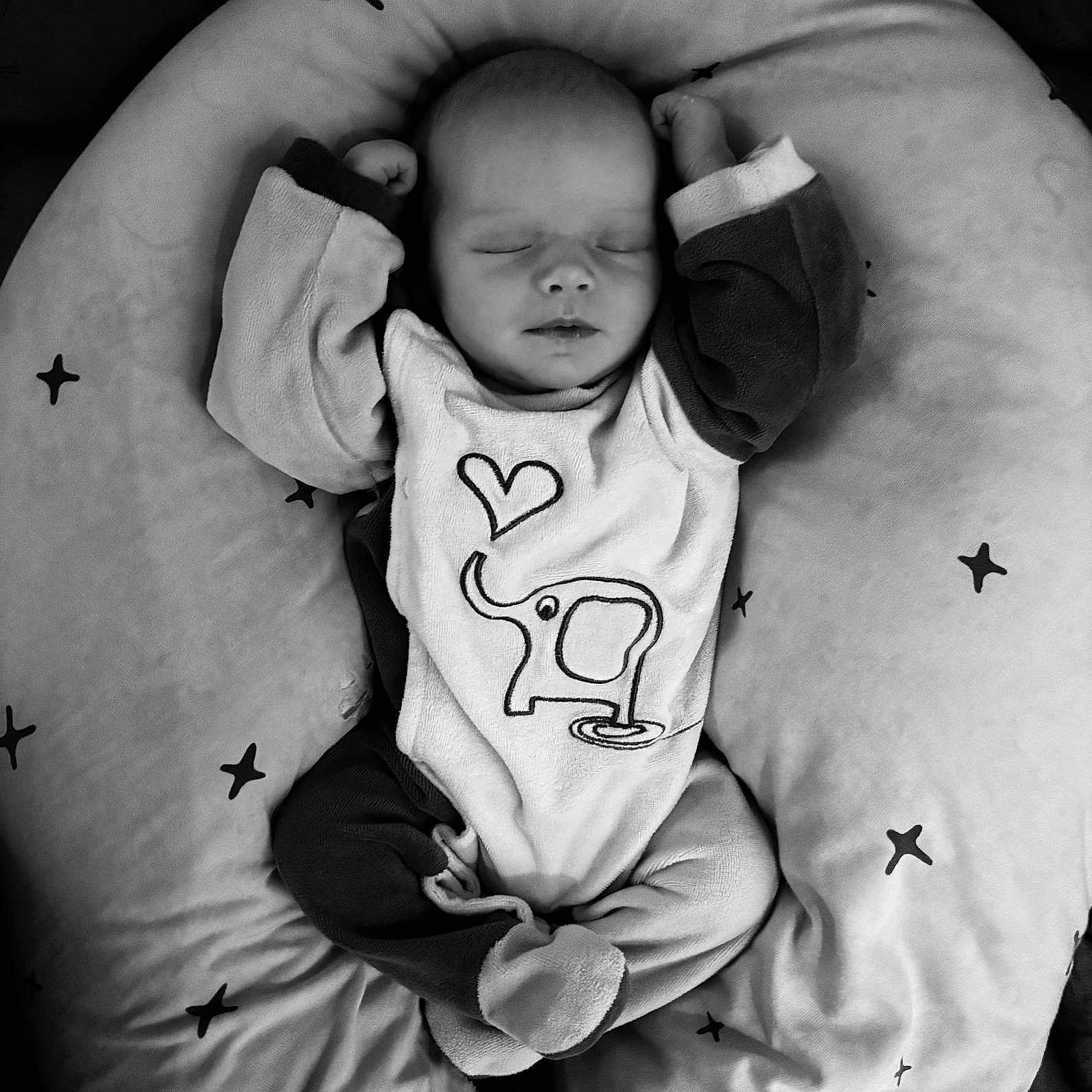 Mia participe au concours pour gagner de l'argent avec cette photo : baby, babywear, black_and_white, child, clothing, cozy, cushion, cute, elephant, heart, infant, onesie, pattern, peaceful, pillow, portrait, resting, sleeping, soft, star
