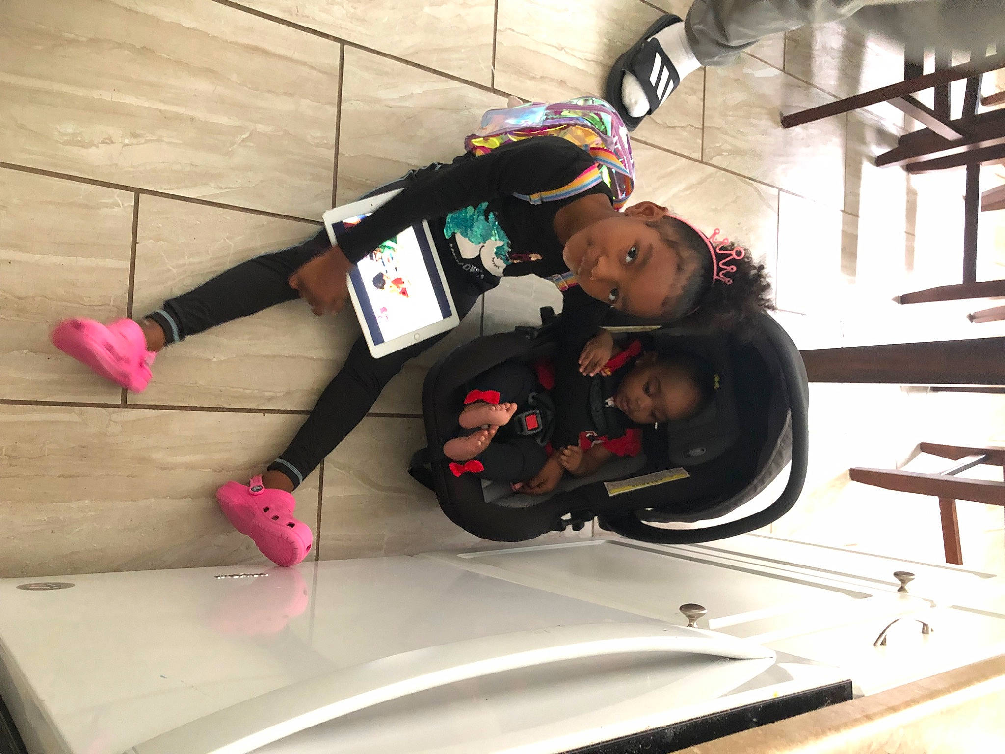 Kennedi is registered to the contest to win money with this photo: auto_part, automotive_design, automotive_exterior, automotive_window_part, bumper, flooring, fun, human_leg, leg, person, personal_protective_equipment, recreation, sandal, sitting, sportswear, t_shirt, thigh, toddler, vehicle_door, window