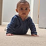 baby, child, crawling, blue_hoodie, carpet, indoor, person, face, hands, floor, hallway, curious, young, infant, clothing, portrait, expression, head, eyes, skin